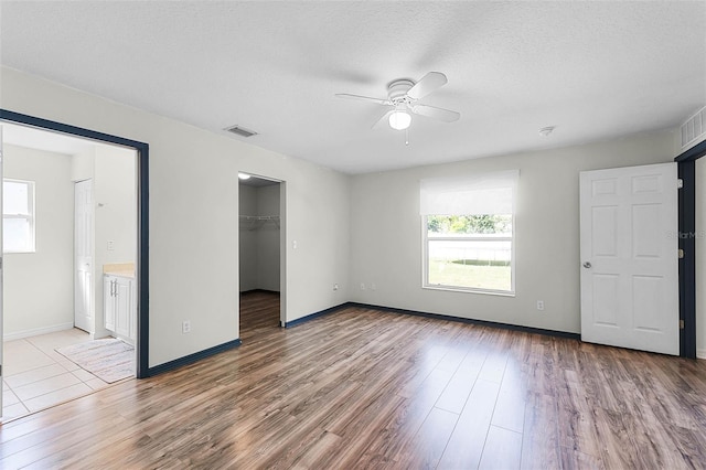 37 Lindsay Dr, Palm Coast, FL 32137 - unfurnished bedroom with a walk in closet, light wood-type flooring, and multiple windows