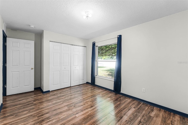37 Lindsay Dr, Palm Coast, FL 32137 - unfurnished bedroom featuring a closet, baseboards, a textured ceiling, and wood finished floors