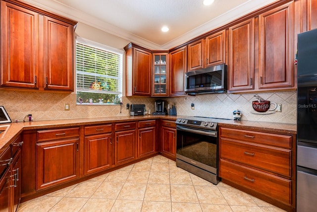 kitchen featuring stainless steel appliances, tasteful backsplash, light tile patterned floors, and ornamental molding