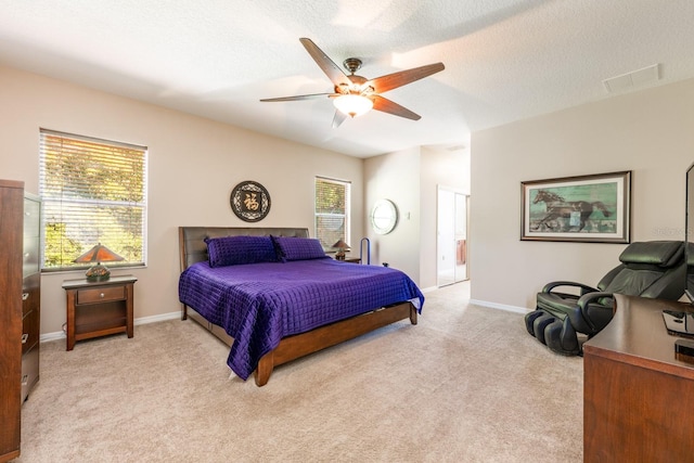 bedroom featuring baseboards, light carpet, ensuite bathroom, a ceiling fan, and visible vents