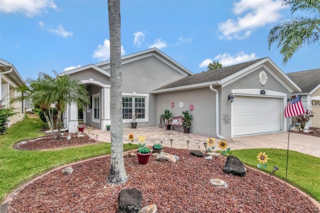 single story home featuring stucco siding, driveway, an attached garage, a front yard, and a patio area