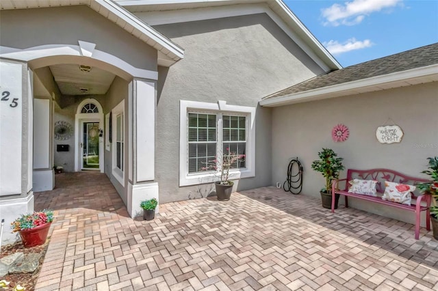 property entrance with a patio area and stucco siding