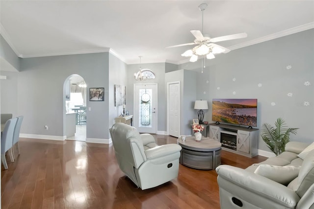 living room featuring crown molding, wood finished floors, ceiling fan with notable chandelier, and baseboards
