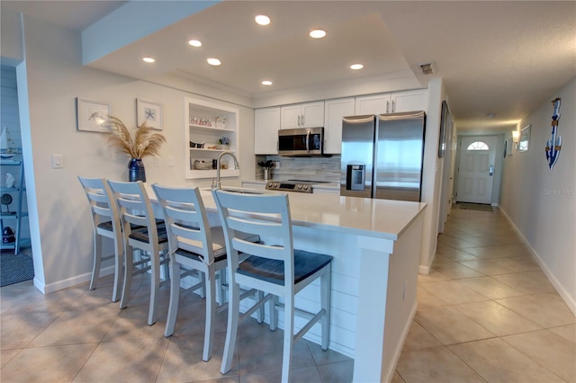 5203 S Atlantic Ave Unit 416B, New Smyrna Beach, FL 32169 - kitchen featuring appliances with stainless steel finishes, a sink, open shelves, a peninsula, and light tile patterned flooring