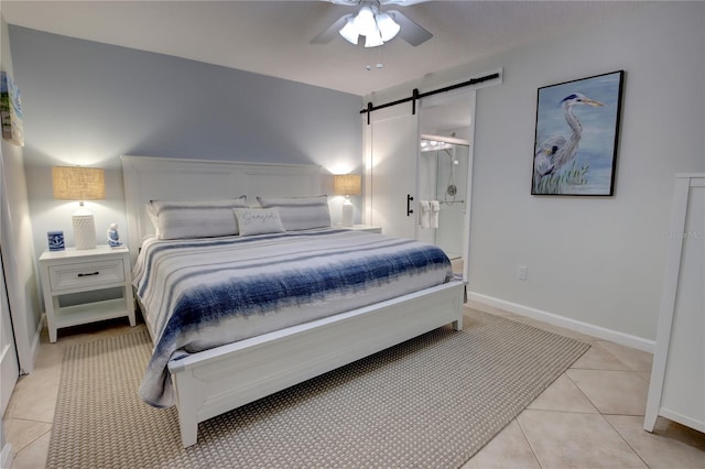 5203 S Atlantic Ave Unit 416B, New Smyrna Beach, FL 32169 - bedroom featuring a barn door, light tile patterned floors, baseboards, and ceiling fan