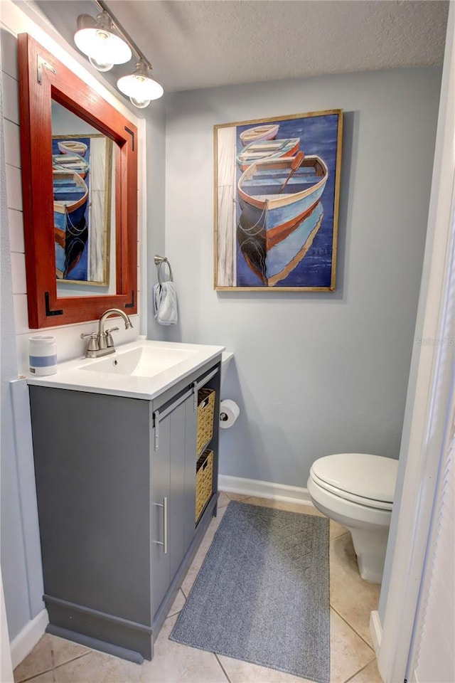 5203 S Atlantic Ave Unit 416B, New Smyrna Beach, FL 32169 - bathroom with toilet, vanity, tile patterned flooring, a textured ceiling, and baseboards