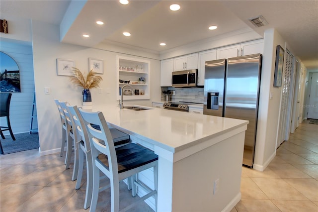5203 S Atlantic Ave Unit 416B, New Smyrna Beach, FL 32169 - kitchen featuring a sink, appliances with stainless steel finishes, white cabinetry, a breakfast bar, and light countertops