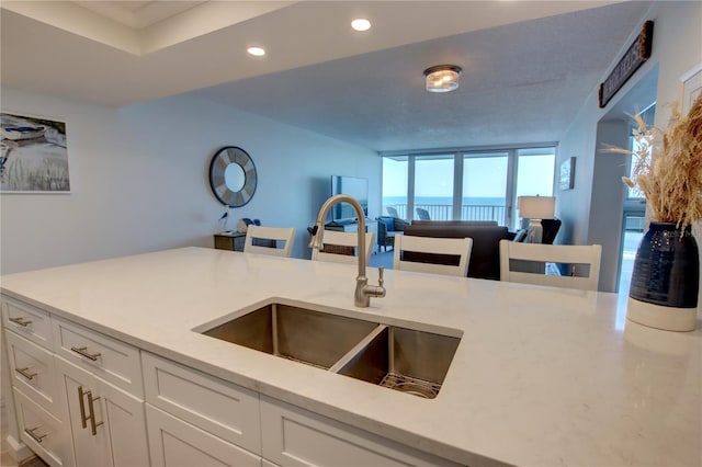5203 S Atlantic Ave Unit 416B, New Smyrna Beach, FL 32169 - kitchen featuring a sink, white cabinetry, recessed lighting, and open floor plan