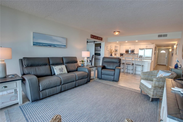 5203 S Atlantic Ave Unit 416B, New Smyrna Beach, FL 32169 - living area with a textured ceiling and light tile patterned floors