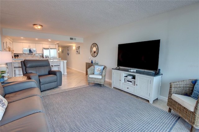 5203 S Atlantic Ave Unit 416B, New Smyrna Beach, FL 32169 - living room with baseboards, a textured ceiling, recessed lighting, and light tile patterned flooring