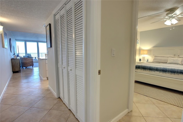 5203 S Atlantic Ave Unit 416B, New Smyrna Beach, FL 32169 - corridor featuring a textured ceiling, light tile patterned floors, and baseboards