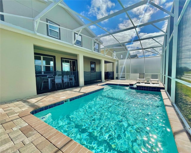 pool featuring glass enclosure and a patio