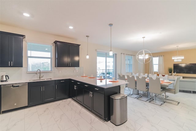 kitchen with marble finish floor, dishwasher, a sink, light countertops, and plenty of natural light