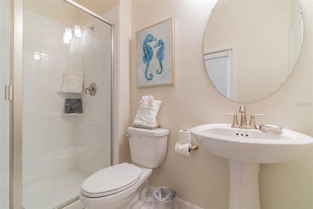 bathroom featuring toilet, baseboards, and a shower stall