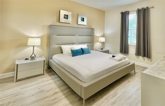 bedroom featuring light wood-type flooring and baseboards