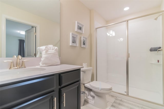bathroom featuring toilet, a shower stall, and vanity