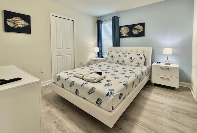 bedroom featuring wood finished floors, a closet, and baseboards