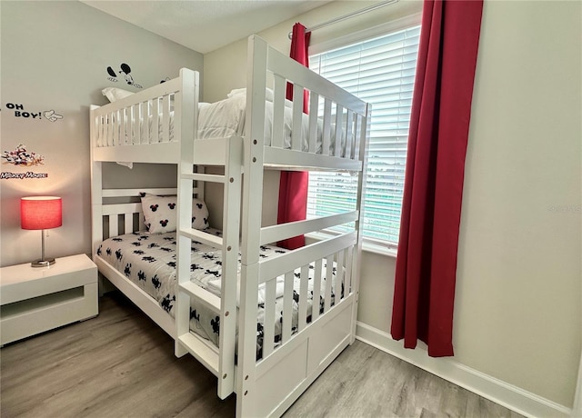 bedroom with baseboards and wood finished floors