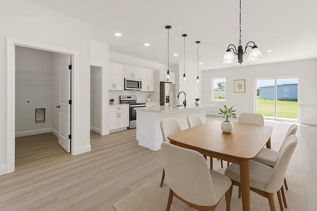 dining area featuring light wood finished floors, recessed lighting, a chandelier, and baseboards