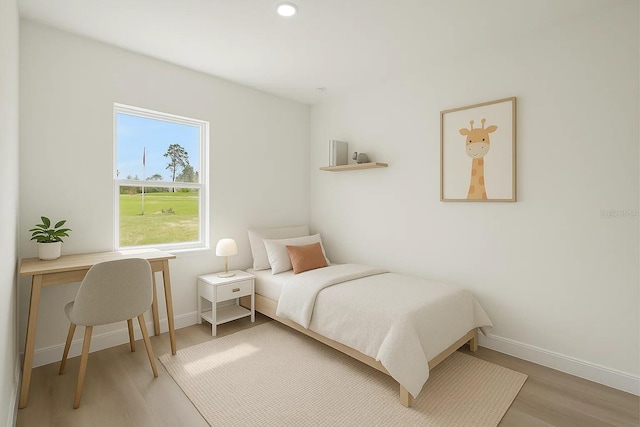 bedroom featuring wood finished floors, baseboards, and recessed lighting