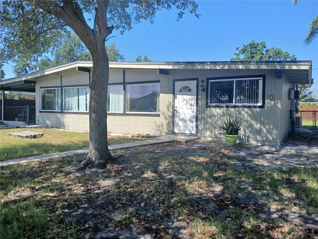 316 Country Club Dr, Oldsmar, FL 34677 - view of front of home featuring concrete block siding, fence, and a front lawn