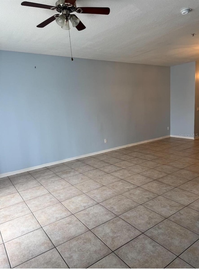 spare room with baseboards, ceiling fan, and a textured ceiling