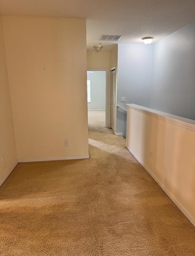 spare room featuring visible vents, carpet flooring, and baseboards