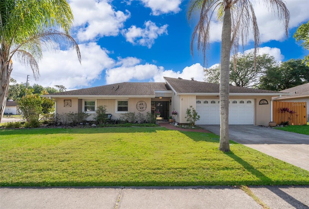 201 Twelve League Cir, Casselberry, FL 32707 - ranch-style house with concrete driveway, stucco siding, a front yard, a garage, and fence