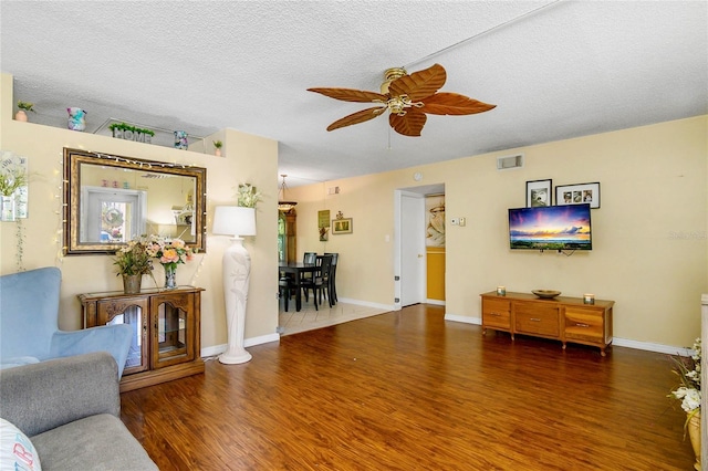 living room with ceiling fan, baseboards, visible vents, and wood finished floors