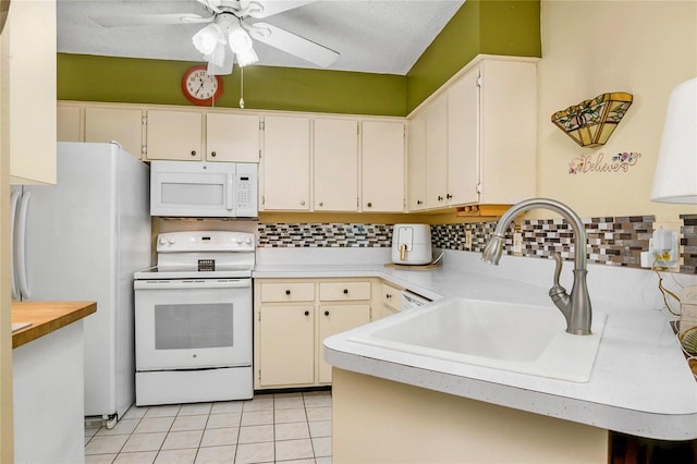 kitchen with tasteful backsplash, white appliances, light countertops, and a sink