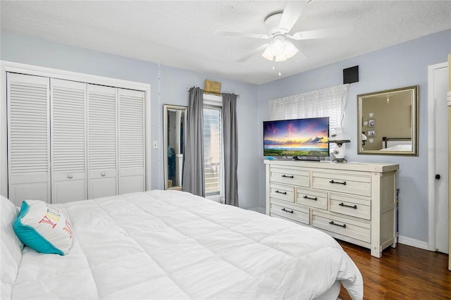 bedroom featuring a closet, baseboards, ceiling fan, a textured ceiling, and dark wood-style floors