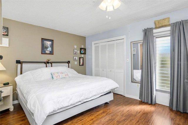 bedroom featuring a ceiling fan, wood finished floors, a closet, and multiple windows