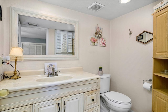 bathroom with visible vents, toilet, and vanity