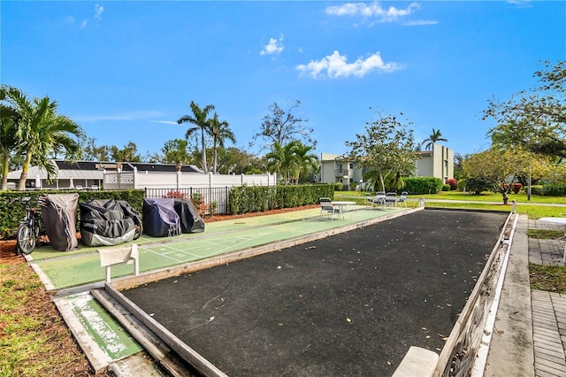 view of home's community featuring fence and shuffleboard