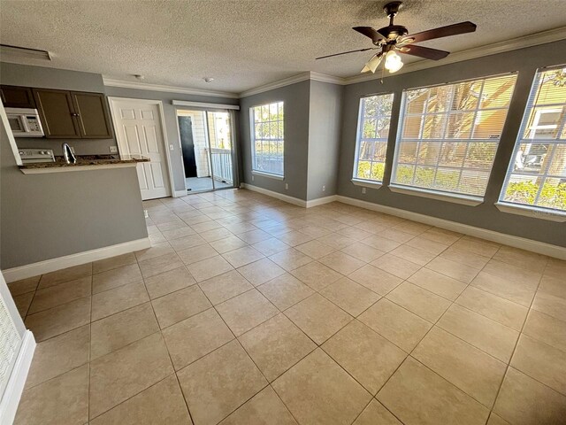 unfurnished living room featuring light tile patterned floors, a healthy amount of sunlight, and a textured ceiling