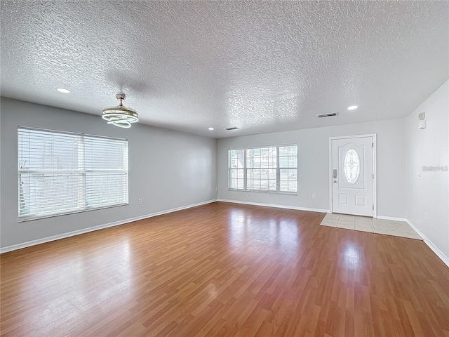 1176 Liberty Hall Dr, Kissimmee, FL 34746 - foyer featuring a textured ceiling, wood finished floors, baseboards, a chandelier, and recessed lighting