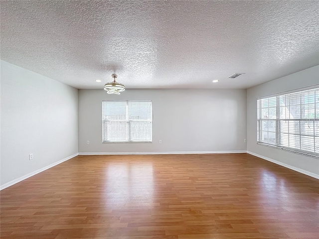1176 Liberty Hall Dr, Kissimmee, FL 34746 - spare room featuring wood finished floors, a textured ceiling, baseboards, and recessed lighting