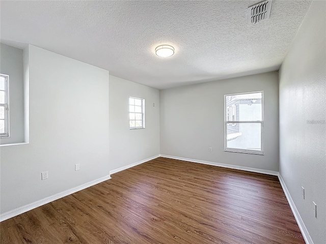 1176 Liberty Hall Dr, Kissimmee, FL 34746 - unfurnished room featuring dark wood-style flooring, a textured ceiling, and baseboards