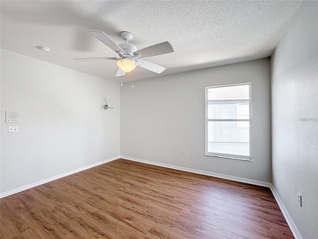 1176 Liberty Hall Dr, Kissimmee, FL 34746 - spare room featuring wood finished floors, baseboards, a ceiling fan, a textured ceiling, and a smoke detector