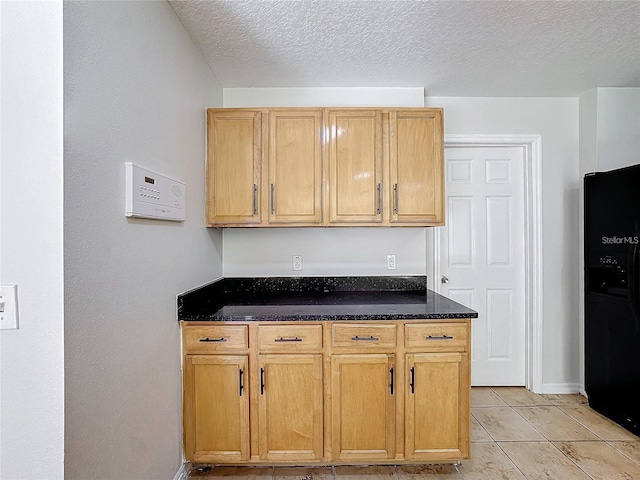 1176 Liberty Hall Dr, Kissimmee, FL 34746 - kitchen with black refrigerator with ice dispenser, a textured ceiling, baseboards, and light tile patterned floors