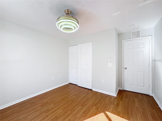 1176 Liberty Hall Dr, Kissimmee, FL 34746 - unfurnished bedroom with wood finished floors, baseboards, and a closet