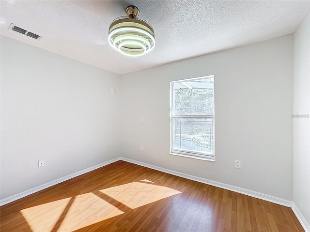 1176 Liberty Hall Dr, Kissimmee, FL 34746 - spare room featuring baseboards, wood finished floors, and a textured ceiling