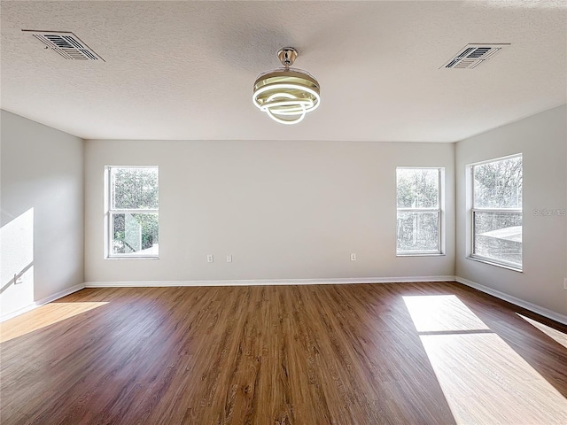 1176 Liberty Hall Dr, Kissimmee, FL 34746 - spare room with dark wood-style flooring, baseboards, a chandelier, and a textured ceiling