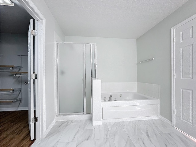 1176 Liberty Hall Dr, Kissimmee, FL 34746 - full bath with a bath, a stall shower, marble finish floors, baseboards, and a textured ceiling