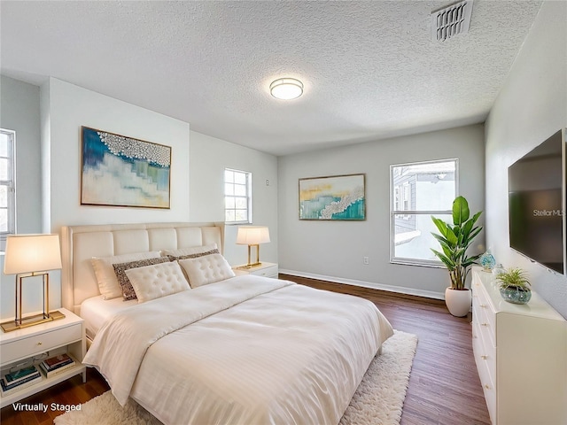 1176 Liberty Hall Dr, Kissimmee, FL 34746 - bedroom featuring dark wood-style flooring, baseboards, and a textured ceiling