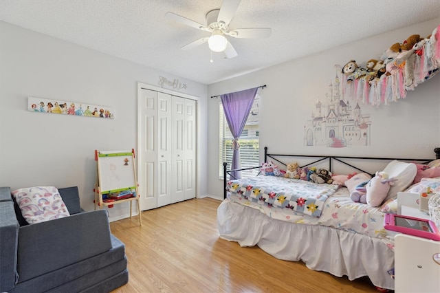 bedroom featuring a ceiling fan, wood finished floors, a textured ceiling, and a closet