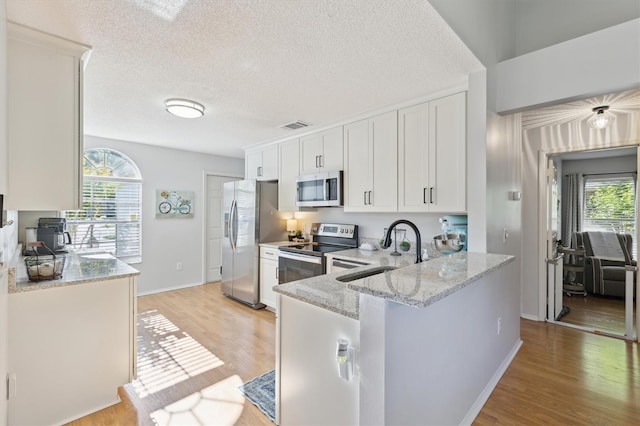 kitchen featuring visible vents, a sink, white cabinetry, and appliances with stainless steel finishes
