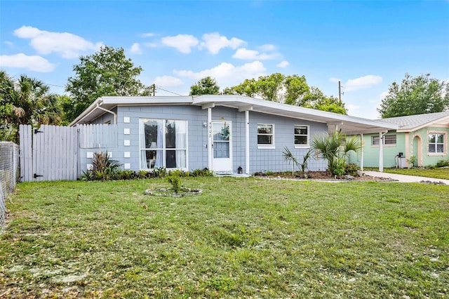 view of front facade with a front yard, driveway, fence, and a carport