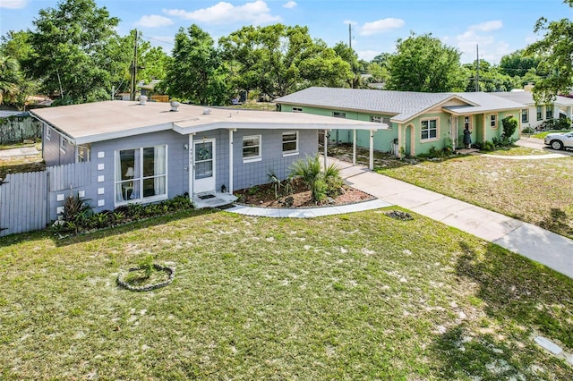 ranch-style house featuring concrete driveway, fence, a front lawn, and an attached carport