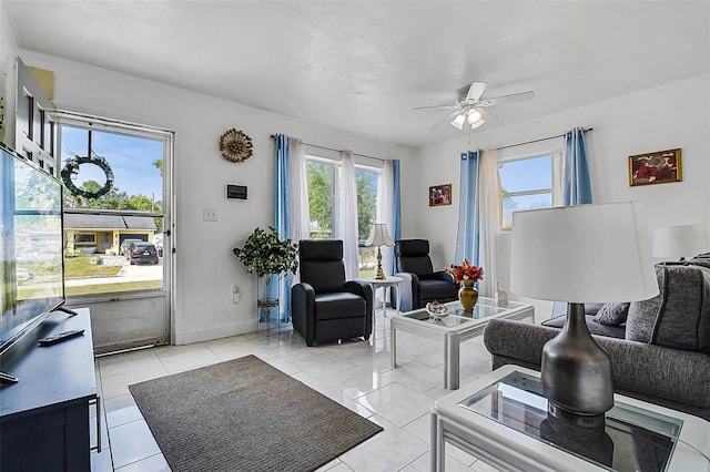 living room with ceiling fan and baseboards